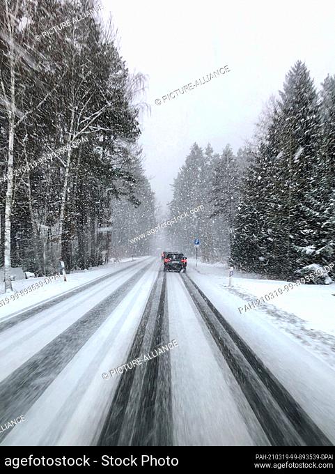 19 March 2021, Saxony, Rodewisch: Cars drive along a country road in heavy snowfall. With temperatures below freezing and snow showers