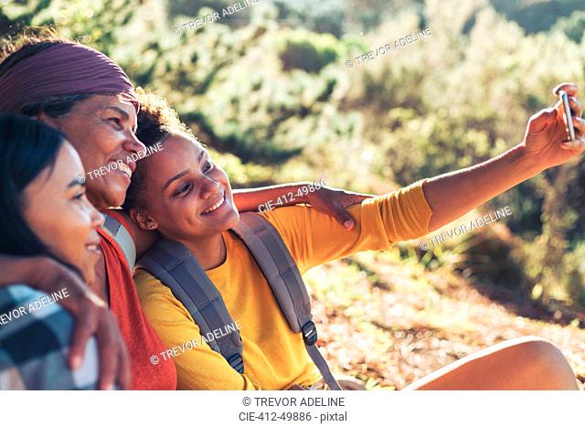 Happy mother and daughter hikers taking selfie with camera phone