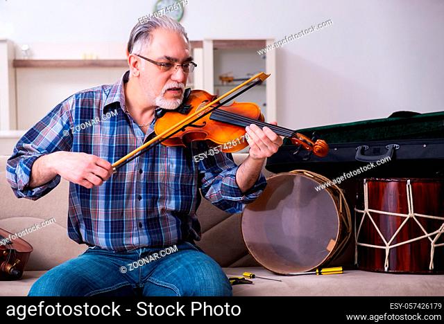 Senior repairman repairing musical instruments at home