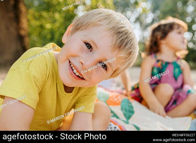Cute kids sitting at beach on sunny day