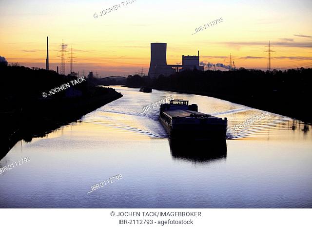 Cargo ship at dawn, Datteln-Hamm-Kanal, canal, near Waltrop, Trianel coal-fired power plant on Stummhafen at back, North Rhine-Westphalia, Germany, Europe