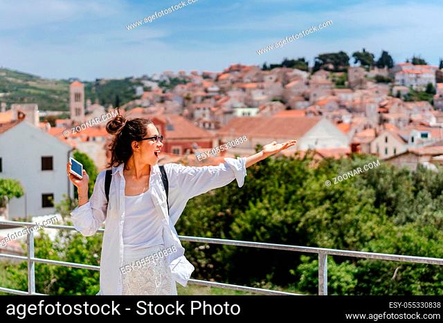 Young beautiful woman posing for the camera on the background of a small Croatian town