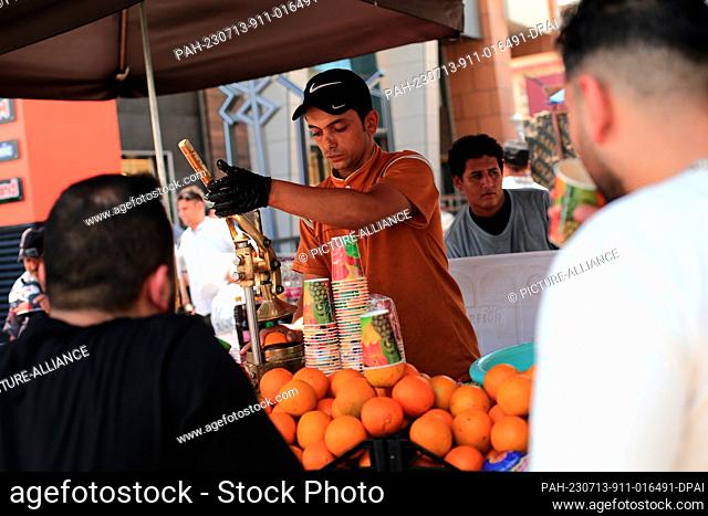 13 July 2023, Iraq, Baghdad: A vendor runs his juice business at a roadside during a hot summer day at Al-Shorja market. Photo: Ameer Al-Mohammedawi/dpa