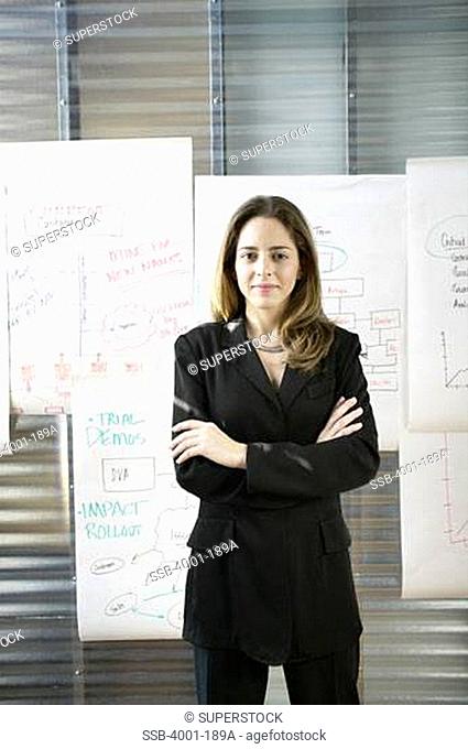 Businesswoman standing in an office with her arms crossed