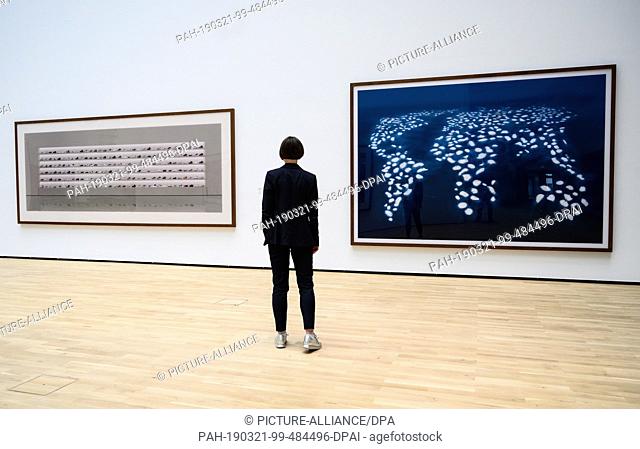21 March 2019, Lower Saxony, Wolfsburg: A woman looks at the artworks ""Untitled V"" (1997, l) and ""Dubai World III"" (2008