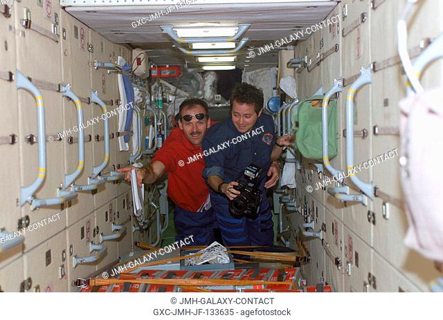 Astronauts Daniel W. Bursch (right), Expedition Four flight engineer, and Steven L. Smith, STS-110 mission specialist, traverse through the functional cargo...