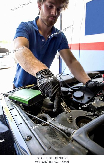 Mechanic placing a battery clip in a car