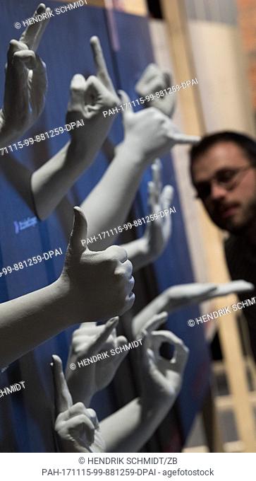 A man takes a look at plaster hands showing different gestures at the Industriemueseum (lit. Industry Museum) in Chemnitz, Germany, 15 November 2017