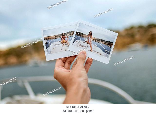 Spain, Ibiza, Hand holding images of man and woman on motor boat