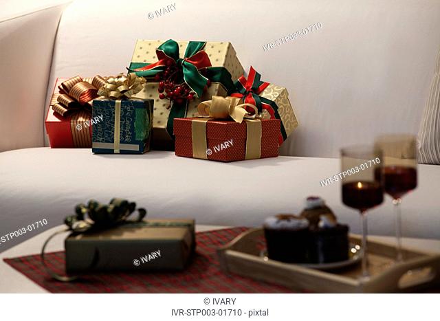 Christmas Gift Boxes On Sofa With Wineglass And Christmas Cake