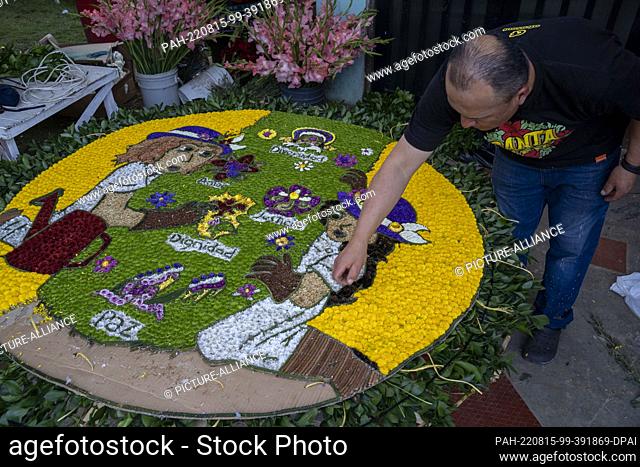 14 August 2022, Colombia, Santa Elena Antioquia: A man works on decorating a ""silleta"", an image designed with flowers