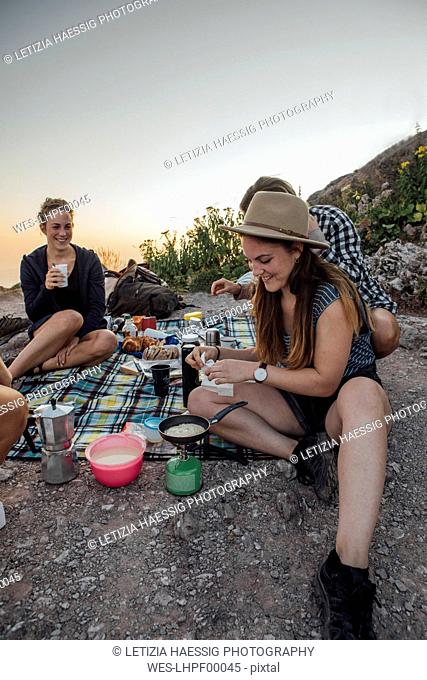 Switzerland, Grosser Mythen, happy girlfriends on a hiking trip having a picnic break at sunrise
