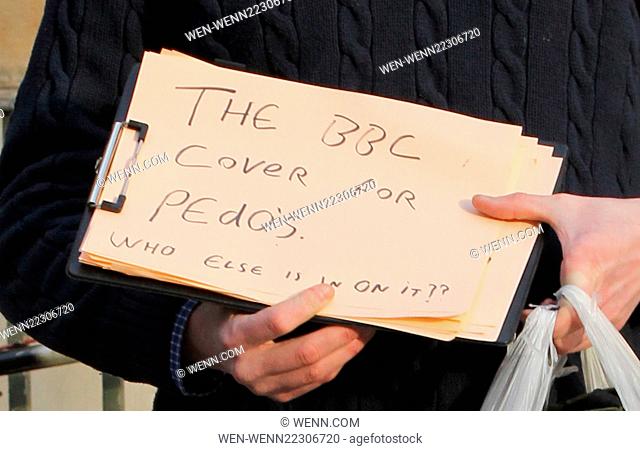 A protester wears a Guy Fawkes mask outside the BBC Radio 1 studios, whilst holding a sign saying 'The BBC cover for Pedo's who else is in on it??' Featuring:...