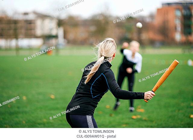 Rear view of female rounders player playing rounders match
