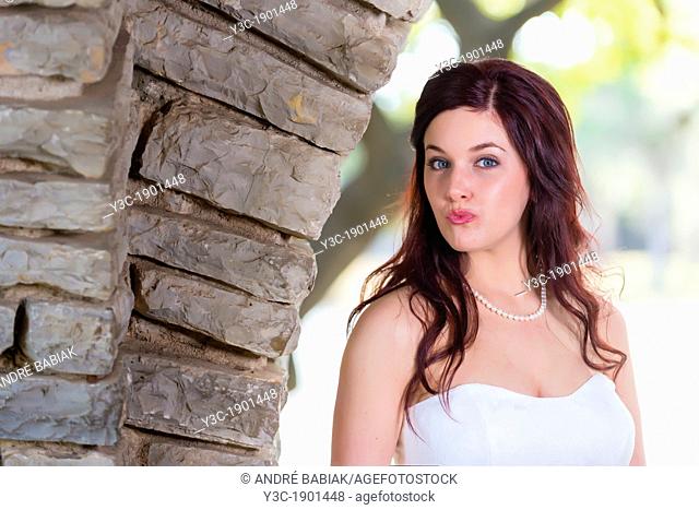 Bridal portrait - A young bride in wedding dress posing at historical looking building at Garner State Park, Concan, Texas, USA, Female Caucasian, 23 years old