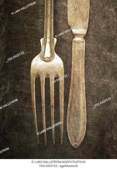 Still life with silverware on table. Knife and fork on a stone background