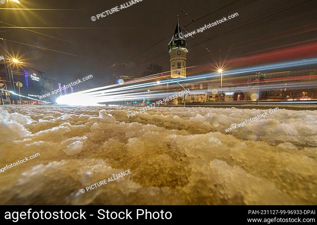 27 November 2023, Hesse, Frankfurt/Main: The evening traffic leaves traces of light at the Friedberger Warte in a wintry atmosphere