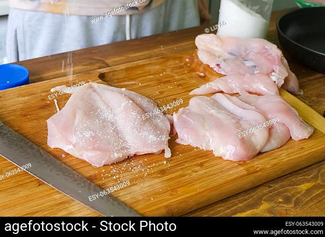 Cutting poultry meat. Broiler breast, chicken meat on a cutting board
