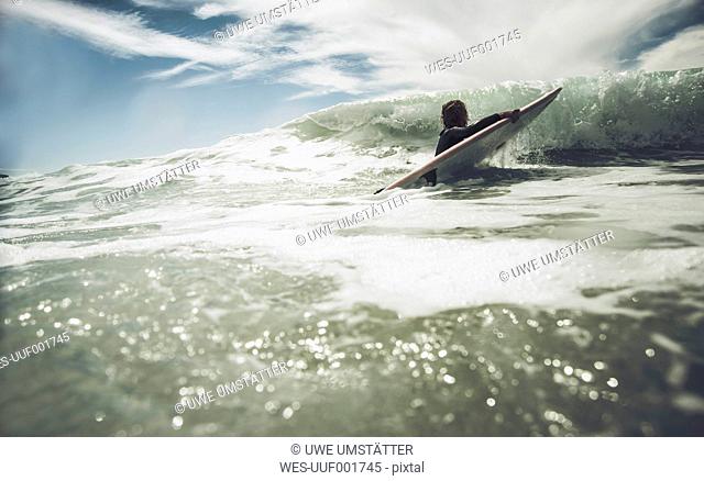 France, Bretagne, Camaret sur Mer, Teenage girl surfing at Atlantic coast