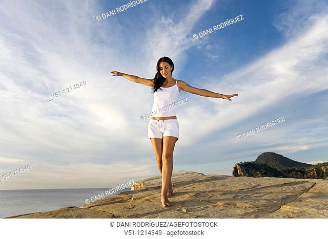 Brunette palyful woman in a cliff in Ibiza, Balearic Islands