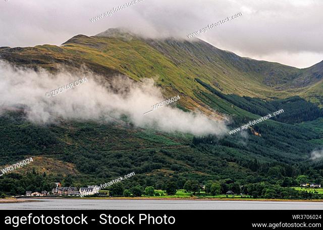 Idyllic mountain landscape with morning early fog covering the peaks at Fort Williams, Glencoe area in the Highlands of Scotland, United Kingdom
