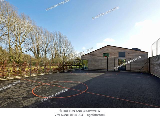 Orchard Spa, Coln Lakes, United Kingdom. Architect: De Matos Ryan, 2013. View across exterior ball court towards spa