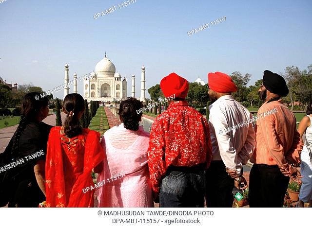 Sikh family viewing at Taj Mahal Seventh Wonders of World on the south bank of Yamuna river , Agra , Uttar Pradesh , India UNESCO World Heritage Site