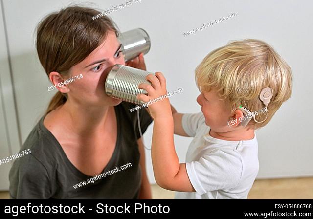 A Boy with Cochlear Implants Playing Tin Can Phone