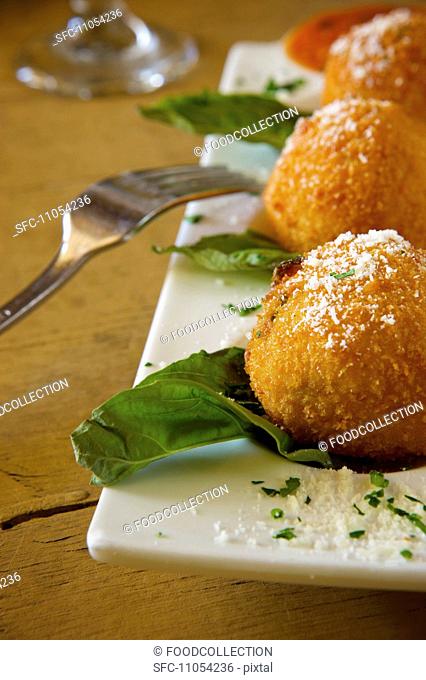 Deep Fried Risotto Balls on a Platter with Parmesan Cheese