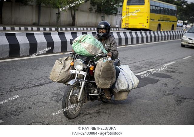 A local resident moves bags on his motorcycle on the streets of Bangalore, India, 06 October 2015. Photo: Kay Nietfeld/dpa | usage worldwide