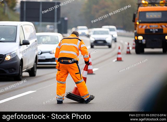 01 November 2022, Berlin: A worker collects traffic cones at the unveiling of Berlin's last and fourth autobahn bear on the rebuilt A114