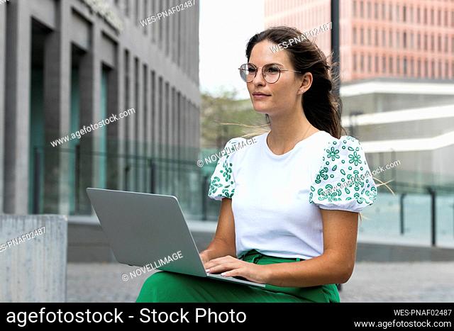 Young businesswoman contemplating while working on laptop