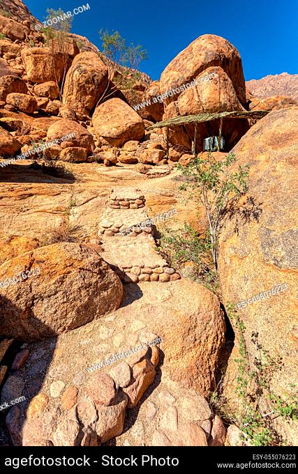 stone road to cave with bushmen rock paintings White Lady in Brandberg mountain area in Namibia with prehistoric archeological sign