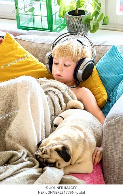 Boy with headphones on sofa