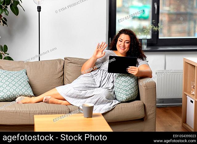 woman with tablet pc having video chat at home