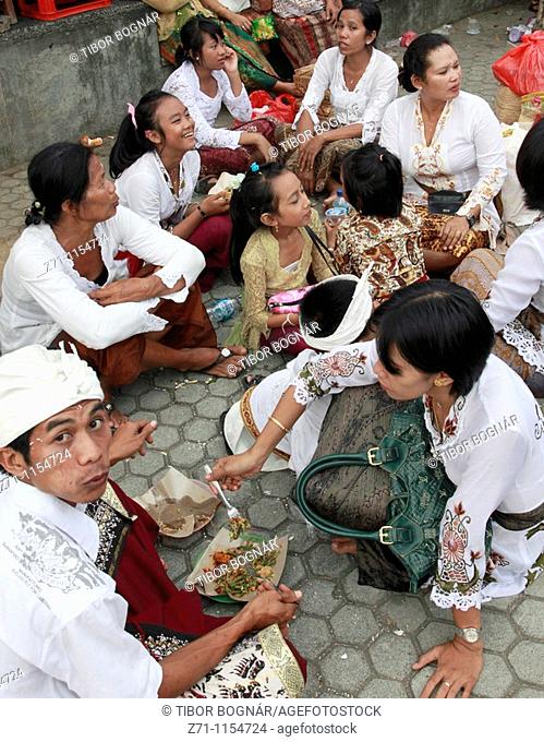 Indonesia, Bali, Mas, temple festival, group of people eating in the street