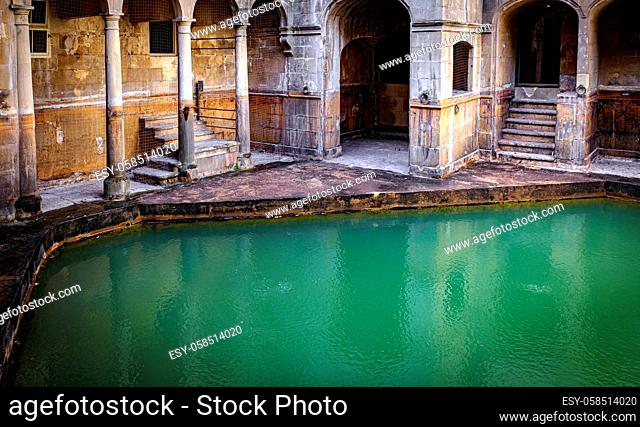 water and buildings in an old roman bath in the city of Bath in the united kingdom england