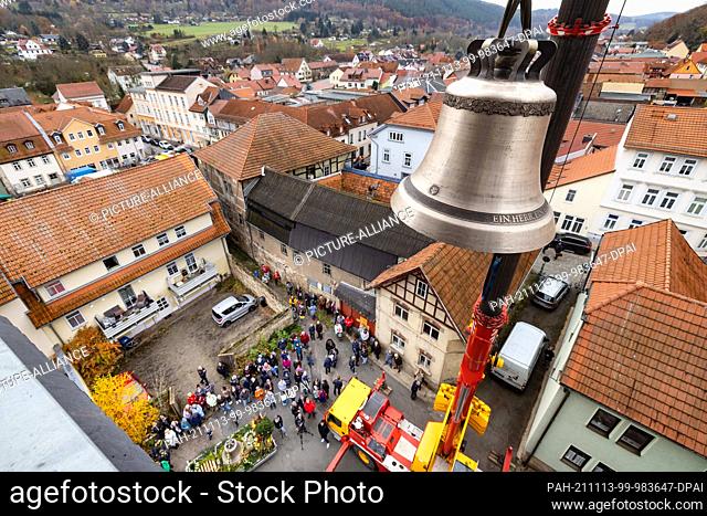 13 November 2021, Thuringia, Bad Blankenburg: With a crane the first of two new bells is lifted into the tower of the St