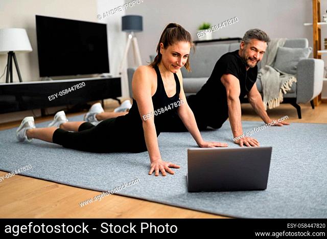 Couple Doing Online Stretching Class Workout And Fitness Exercise