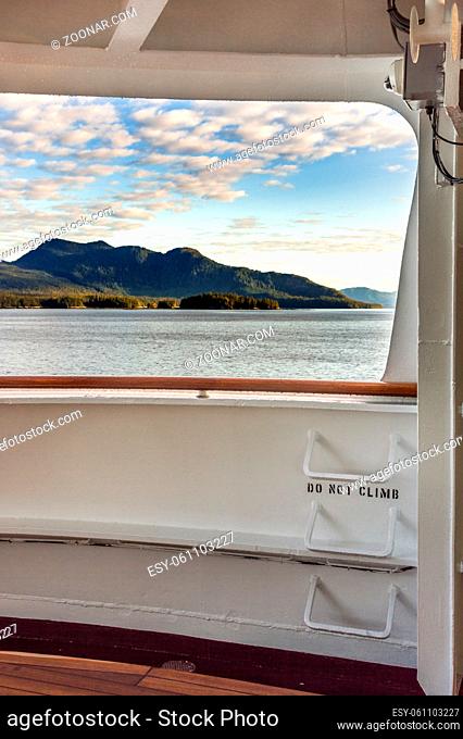 Metal ladder rungs on cruise ship deck with words - do not climb - and view of mountain scenery in background ner Ketchikan, Alaska