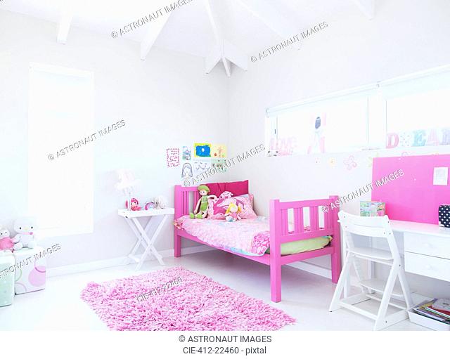Girl's bedroom with pink bed, rug and toys