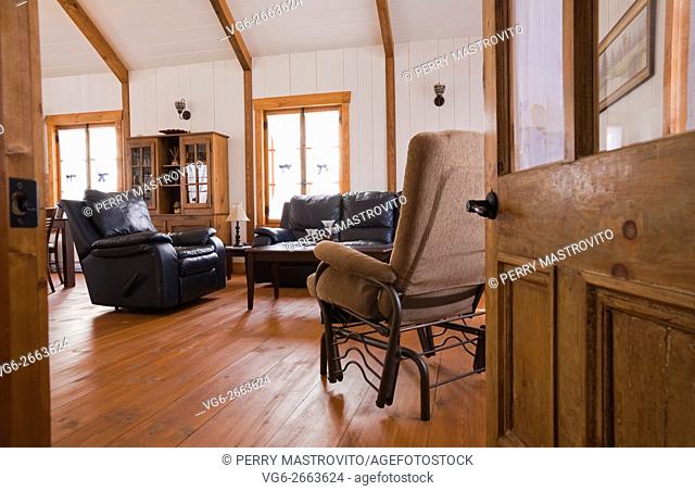 Living room inside the extension of a Canadiana cottage style fieldstone residential home built to look old in 2002, Quebec, Canada