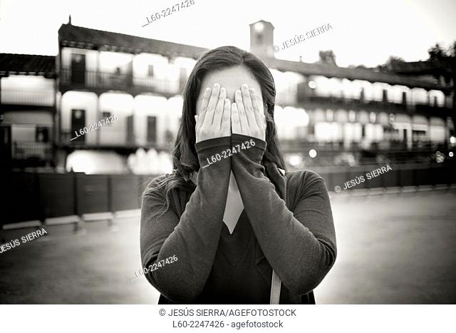 Girl with hand over eyes, Chinchón square, Comunidad de Madrid, Spain