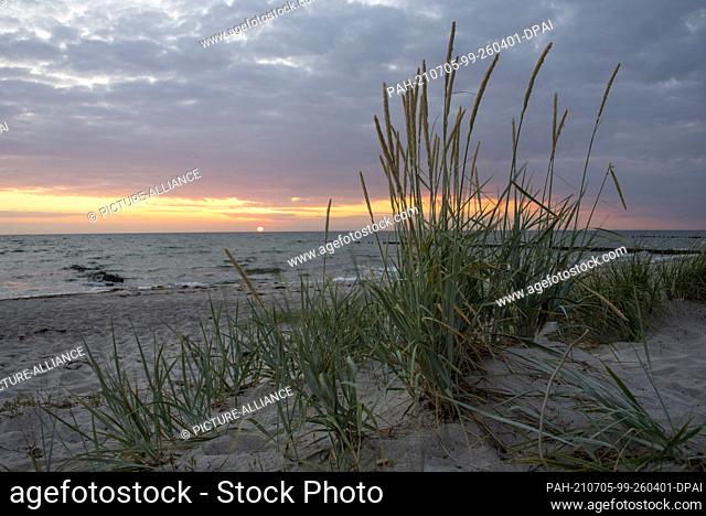 26 June 2021, Mecklenburg-Western Pomerania, Hiddensee: The sun sets on the beach of Hiddensee. Locals also affectionately call their island ""Dat söte...