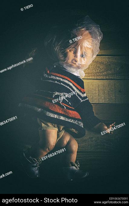 old doll with plastic bag on her head