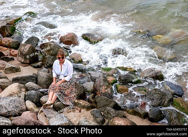 RUSSIA, KALININGRAD REGION - JULY 16, 2023: A woman poses by the rocks on the Baltic Sea coast in Zelenogradsk, 28km north of Kaliningrad
