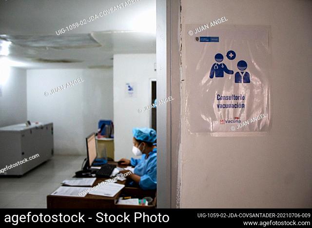 A nurse sits on a computer as a sign that reads ""Vaccination room"" during the novel coronavirus (COVID-19) pandemic PCR testing in Hernan
