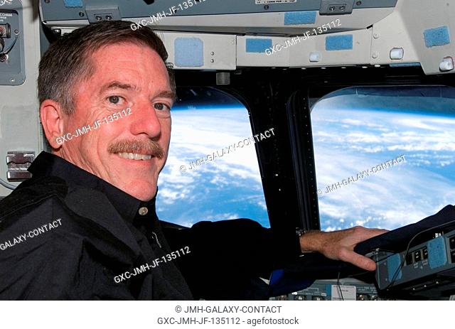 Astronaut Jim Reilly, STS-117 mission specialist, occupies the commander's station on the flight deck of Space Shuttle Atlantis during flight day 12 activities