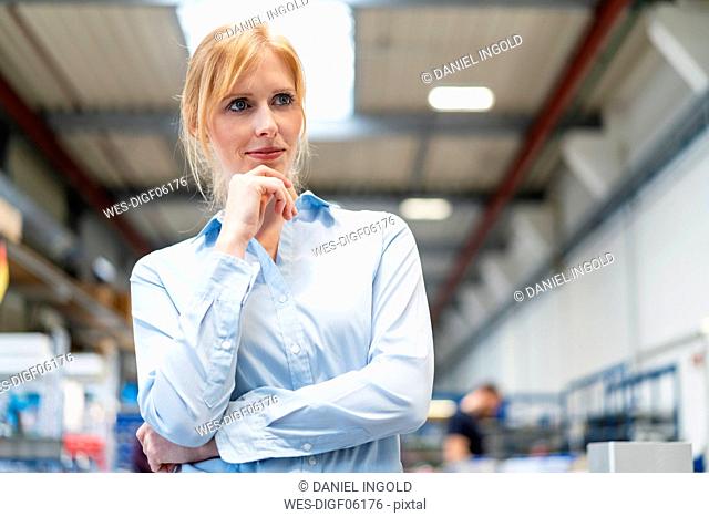 Portrait of businesswoman in factory thinking