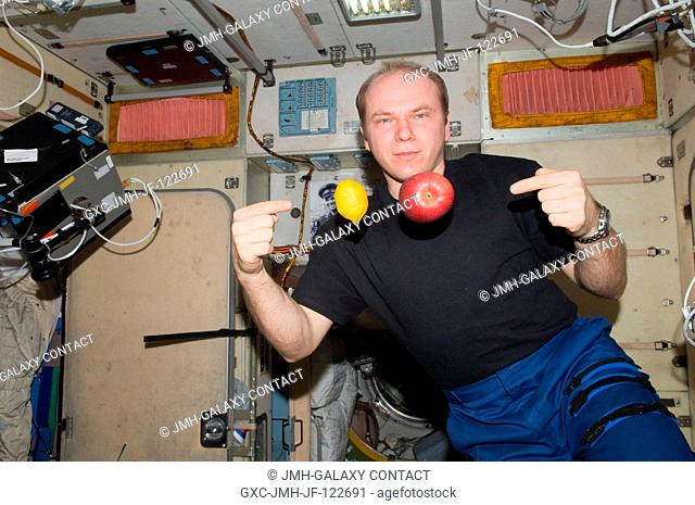 Russian cosmonaut Oleg Kotov, Expedition 23 commander, is pictured near fresh fruit floating freely in the Zvezda Service Module of the International Space...